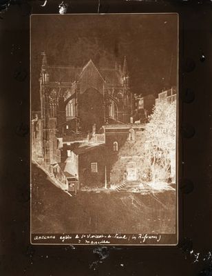 une vieille photo d'un vieux bâtiment avec une tour horloge en arrière-plan