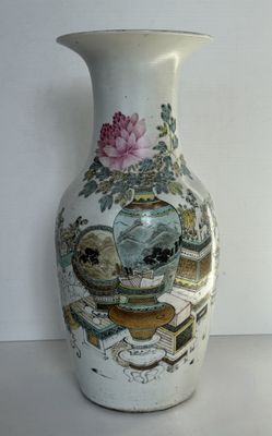 un vase avec un tableau posé sur une table