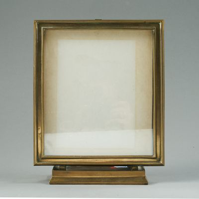 an old picture frame sitting on top of a wooden stand