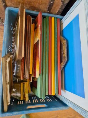 une boîte bleue remplie de livres posée sur une table en bois