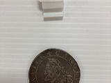 une petite pièce de monnaie sur laquelle est gravé un chiffre, posée sur une table
