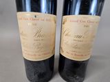 two bottles of red wine sitting next to each other on a table