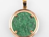 a close up of a green pendant on a white surface