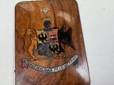a wooden plaque with a coat of arms and a lion on it