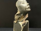 a close up of a sculpture of a head on a block