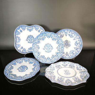 three blue and white plates and a bowl on a black table