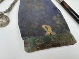 a small purse with a chain and a pen on it