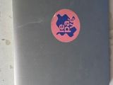 a laptop with a sticker on it sitting on a table