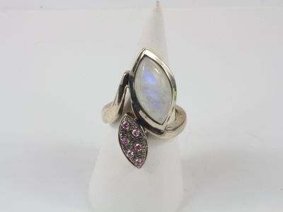 un gros plan d'une bague ornée d'une pierre blanche et d'une pierre violette