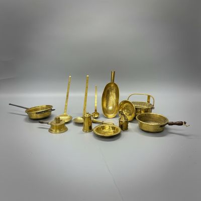 un ensemble d'objets en laiton, comprenant notamment des bougies, des cuillères et d'autres objets