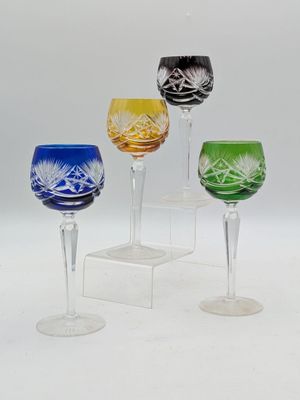 plusieurs verres à vin de différentes couleurs posés sur une table blanche