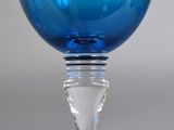 a blue wine glass sitting on top of a table