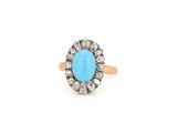 un gros plan d'une bague sertie d'une pierre turquoise sur fond blanc