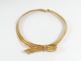 gros plan d'un collier en or sur une surface blanche