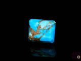 a close up of a blue stone on a black surface