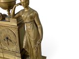 a statue of a woman holding a globe on top of a table