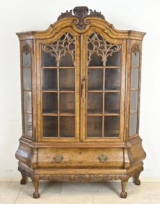 an old wooden china cabinet with glass doors on top of a tiled floor