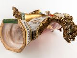 a gold and pink vase on a white surface