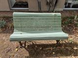 un banc vert situé devant un immeuble