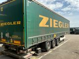 un gros camion vert garé sur un parking