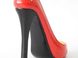 red and black high heeled shoe on a white surface