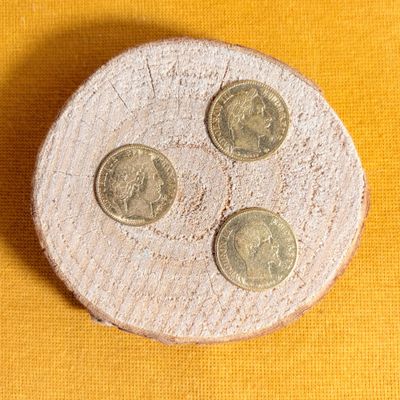 three coins sitting on top of a piece of wood