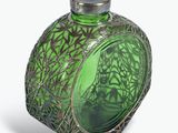 une bouteille en verre vert avec un bouchon argenté, posée sur une surface blanche