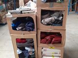 des cartons empilés les uns sur les autres dans un entrepôt rempli de vêtements