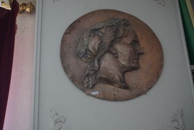 une plaque fixée au mur d'un immeuble sur laquelle figure le portrait d'une femme