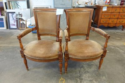 une paire de chaises anciennes avec des assises rembourrées dans une boutique