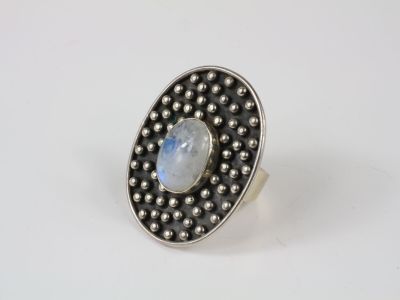 a silver ring with a rainbow stone surrounded by beads