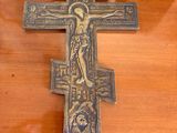 cross on a wooden table with a mirror in the background