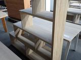 a table with a book shelf in the middle of a room