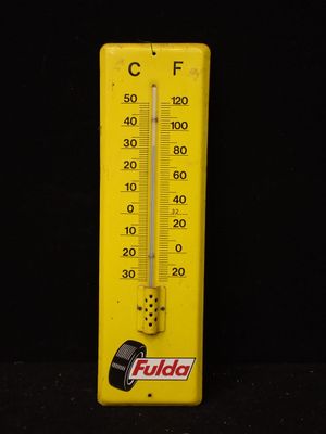 un thermomètre jaune sur fond noir
