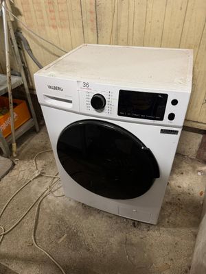 a washing machine that is sitting in the corner of a room