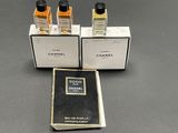 three bottles of perfume sitting on top of a table next to a book