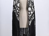 a black and white shawl with fringes on a mannequin