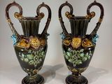 pair of antique vases with floral designs on them on a table
