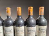 six bottles of wine are lined up on a table