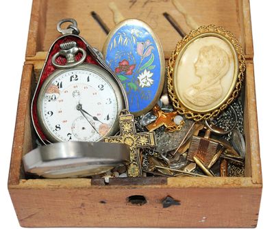 une boîte en bois contenant divers objets, dont une montre de poche