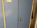 two blue lockers in a room with a sign on the door