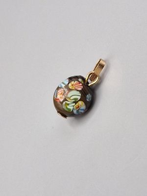 une photo d'un pendentif orné d'un motif floral
