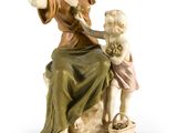 figurine représentant une femme avec un enfant, assise sur un rocher