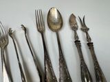 a lot of silver spoons and forks sitting on a table