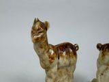 two figurines of animals that are sitting on a table