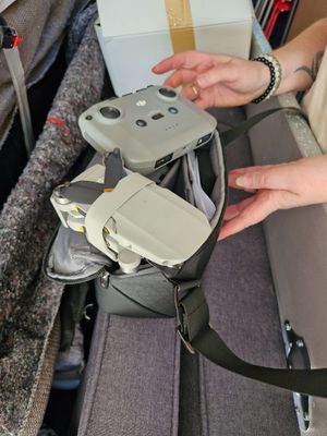 a person that is holding a remote control in a bag