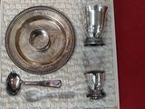 un plateau en argent avec des cuillères, des tasses et un repose-cuillère sur fond rouge