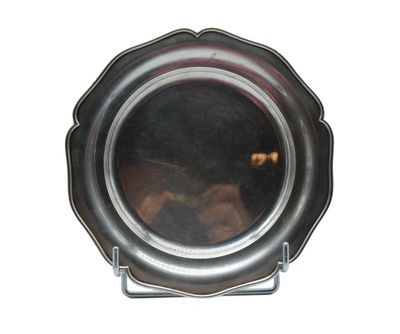 a silver plate on a stand with a reflection of a person in it