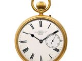 une vieille montre de poche en or avec des chiffres romains et des chiffres romains