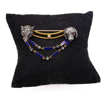 a close up of a black pillow with a gold and blue broochle